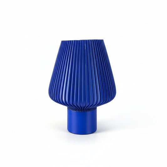 Blue pleated lampshade on a white surface with a blurred background