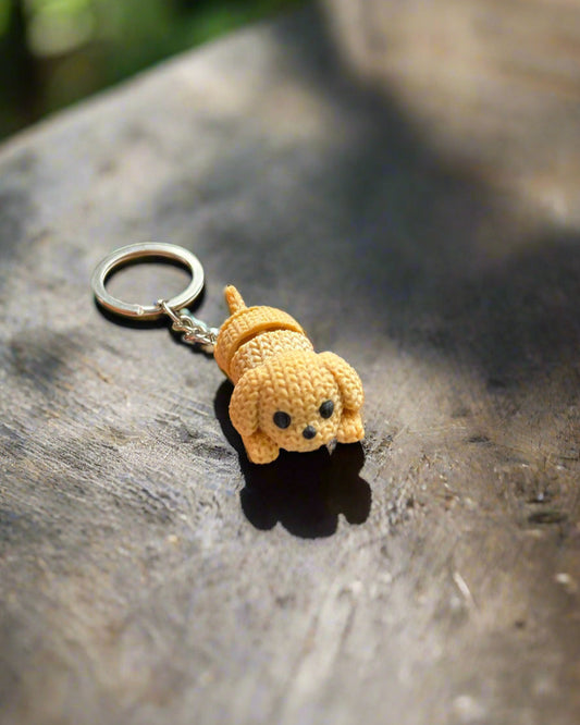 Hand holding a small yellow keychain with a blue and white background