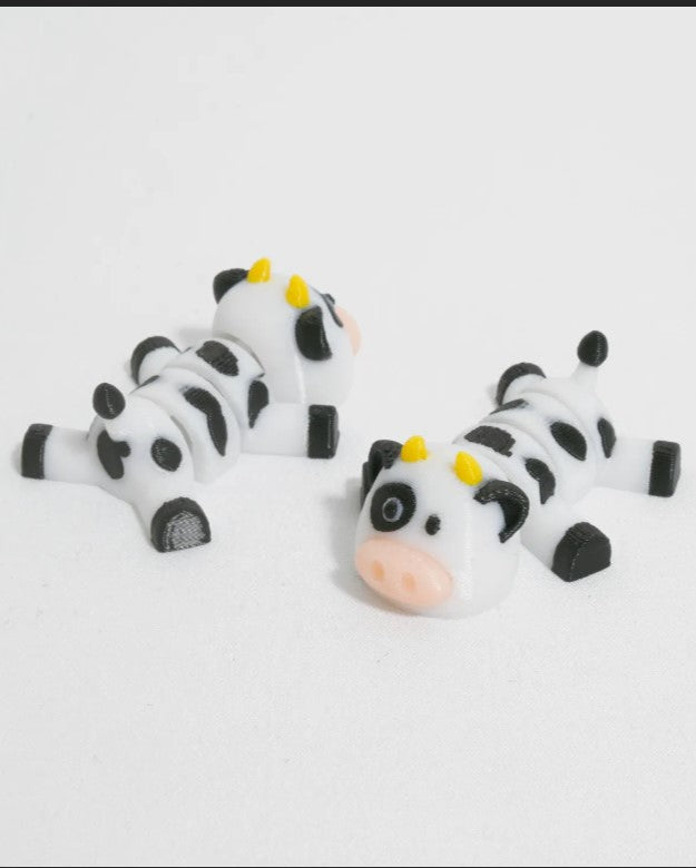 Two cow-shaped figurines on a white background