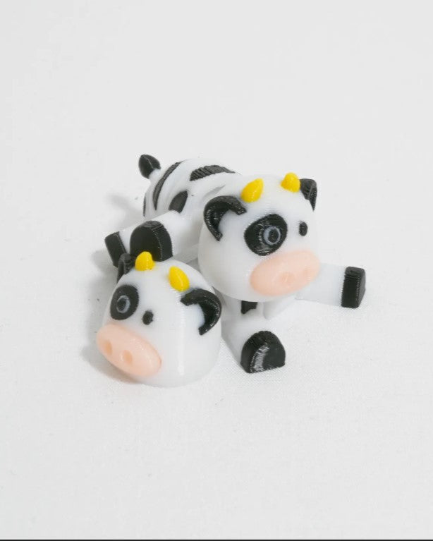 Two cow-shaped figurines on a white background