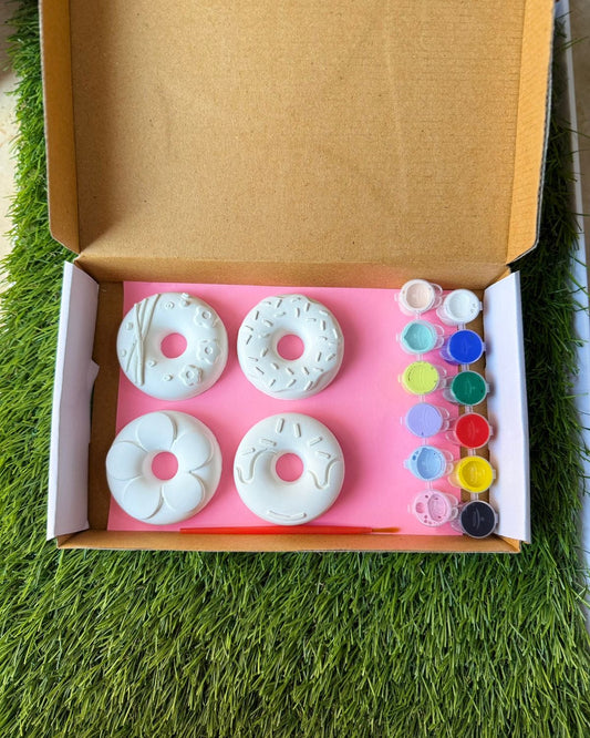 Box with white donut-shaped objects and colorful buttons on a grassy surface