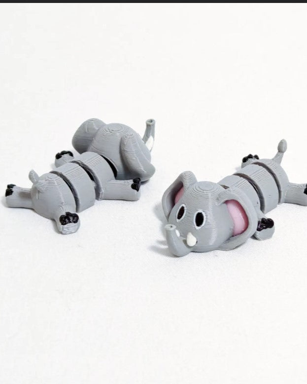 Two gray elephant-shaped slippers on a white background