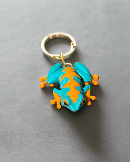 Toy frog with blue and orange design on a wooden surface