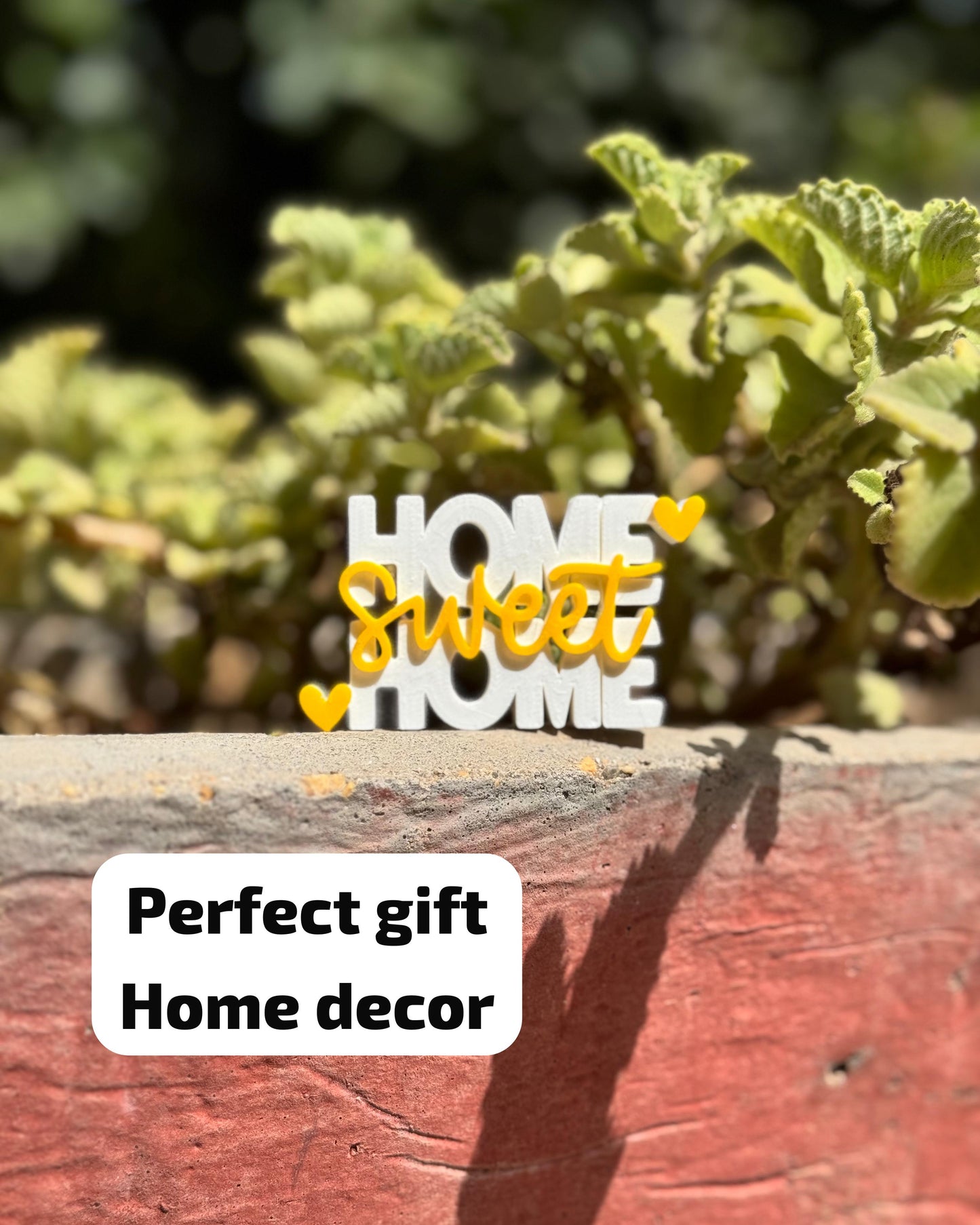 Decorative sign with 'Home sweet home' text on a wooden surface with greenery in the background