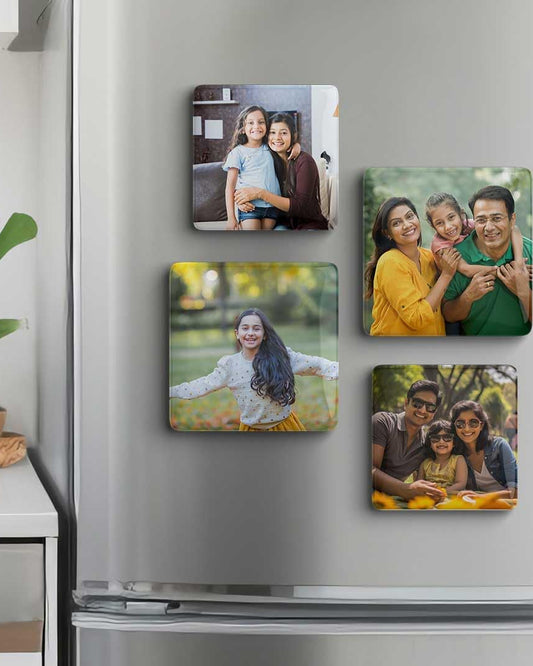 Fridge with family photos as magnets on a white wall.