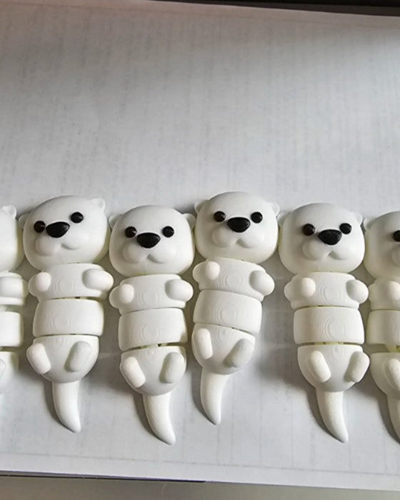 Five white polar bear figurines with black eyes and black noses on a white background