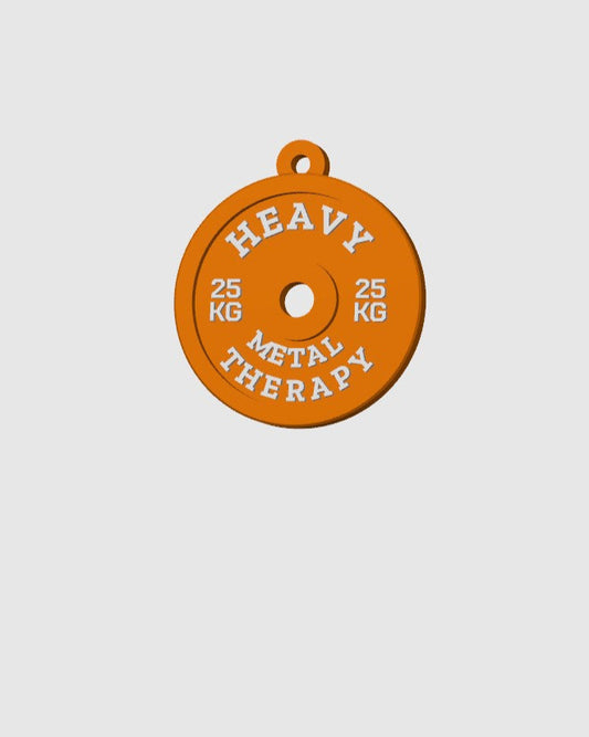 Orange weight plate with 'Heavy Metal Therapy' text on a light gray background