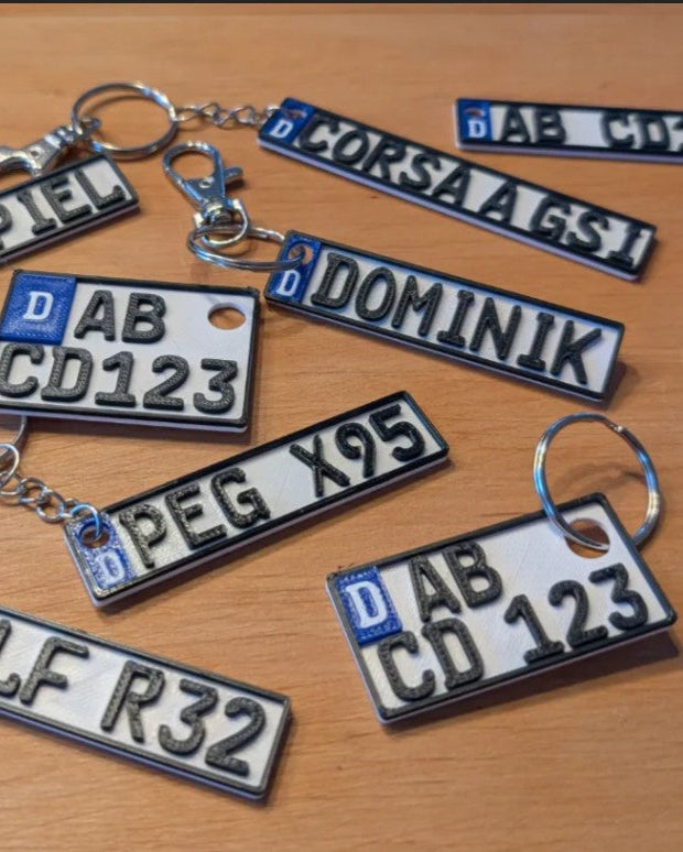 Collection of license plate keychains on a wooden surface
