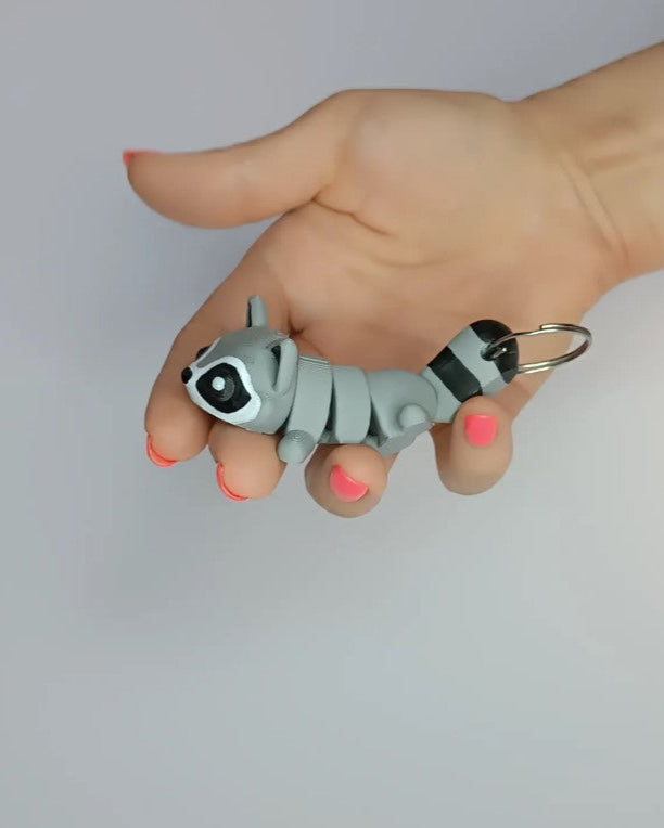 Hand holding a small gray dog-shaped keychain against a plain background