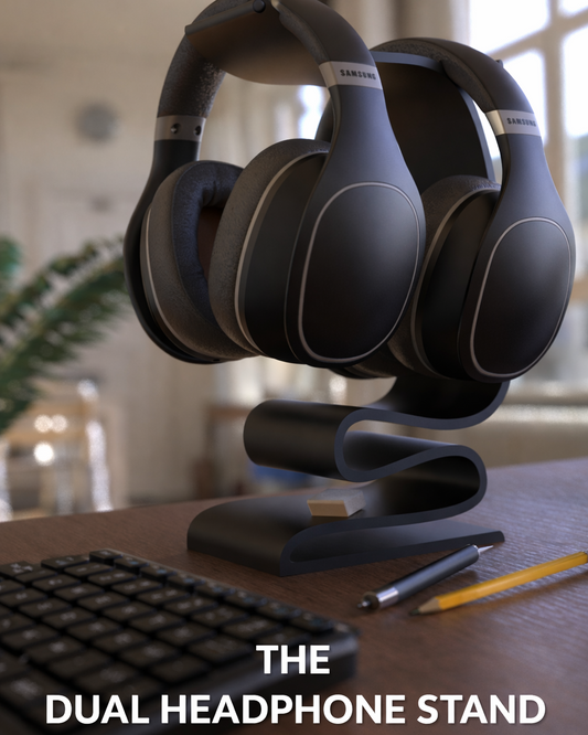 Black dual headphone stand holding two pairs of headphones on a desk.