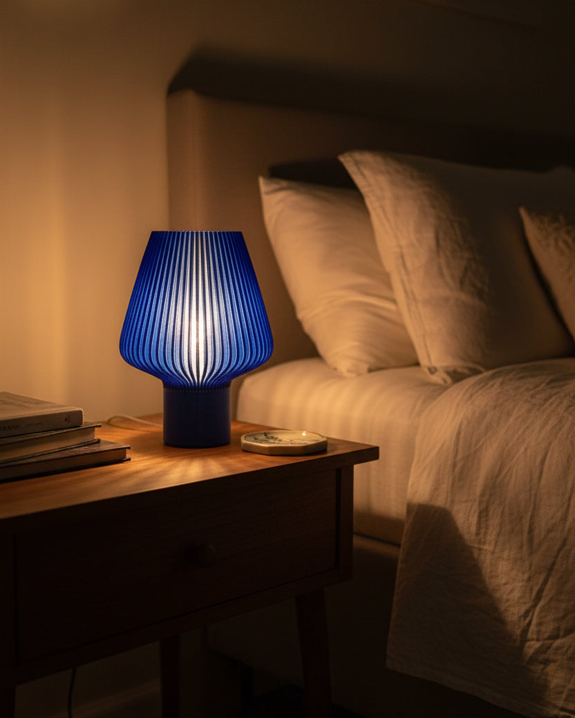 Blue textured lamp on a white surface with a blurred background