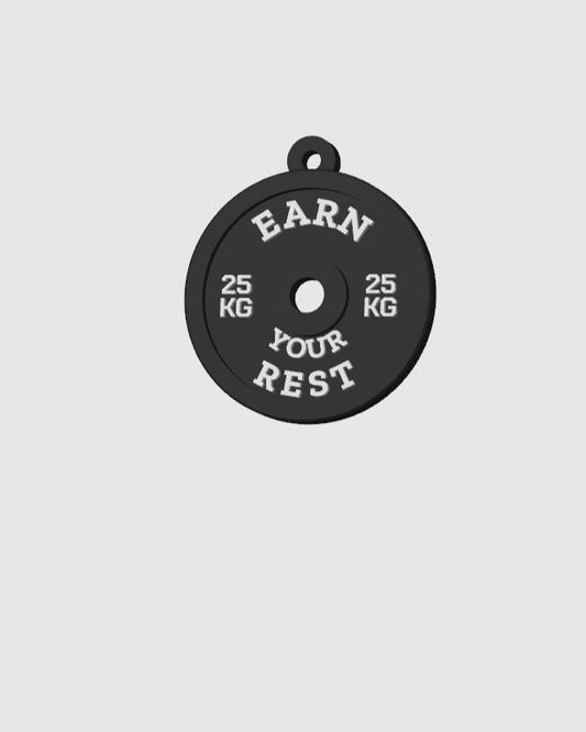 Black weight plate with 'Earn Your Rest' text on a gray background
