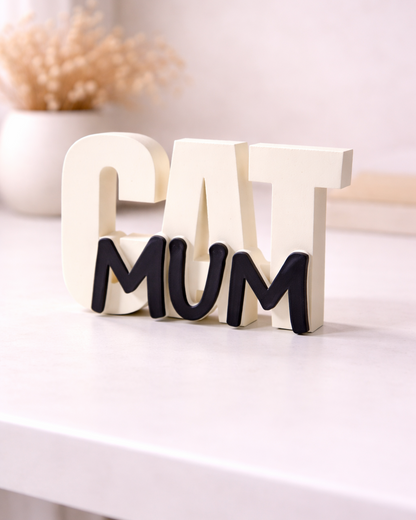 Decorative sign with 'CAT MUM' on a white surface