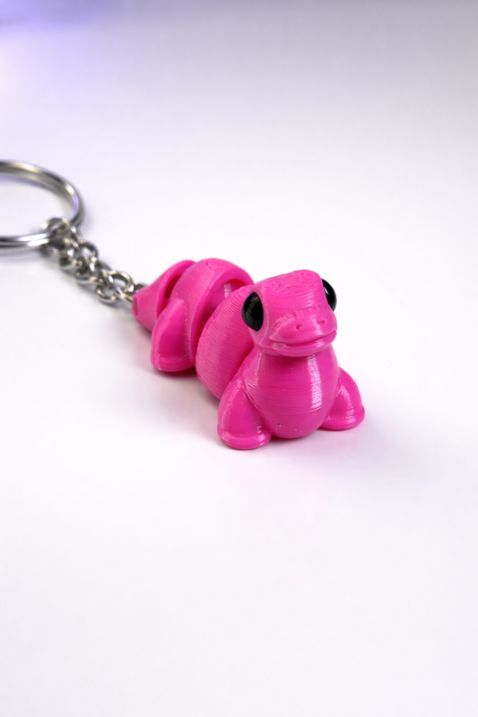 Pink snake-shaped keychain on a white background