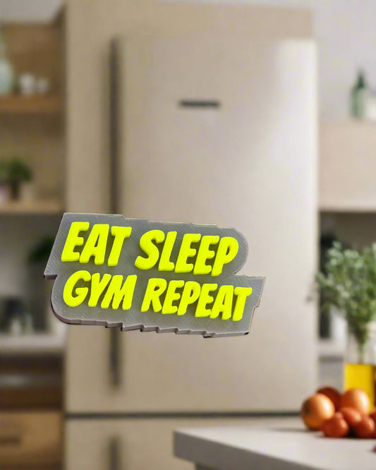 Hand holding a 'Eat Sleep Gym Repeat' sticker in front of a Buddha statue.