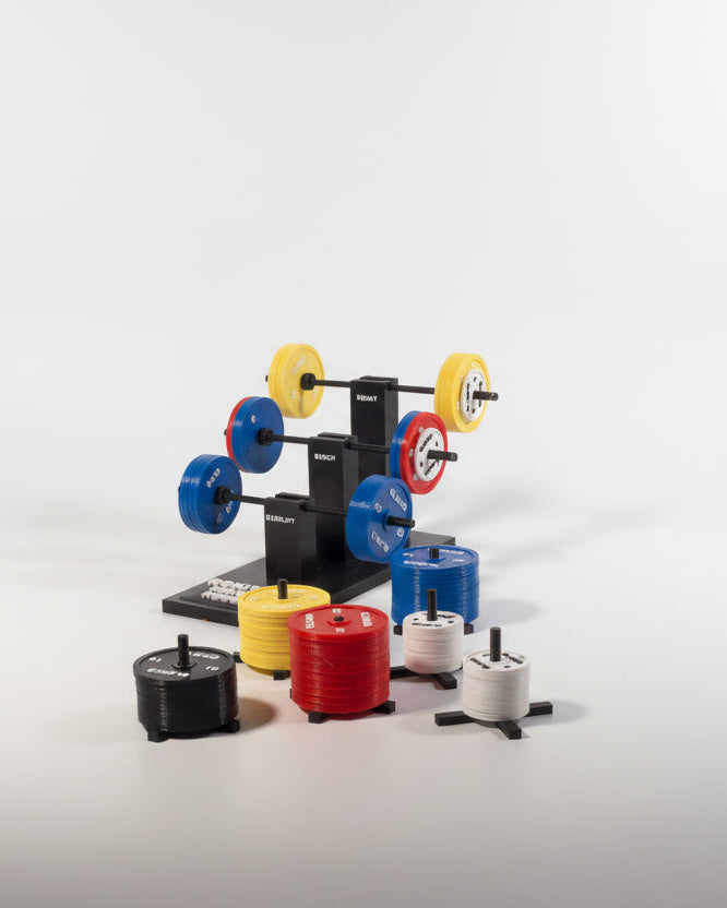 Weightlifting plate storage system with colorful weight plates on a gray surface.