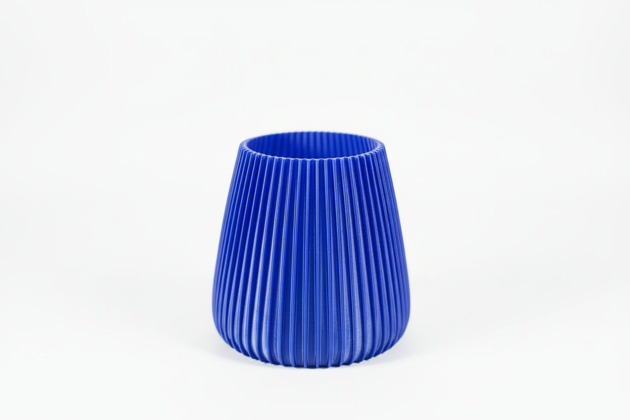 Blue 3D-printed object on a white surface with a blurred background