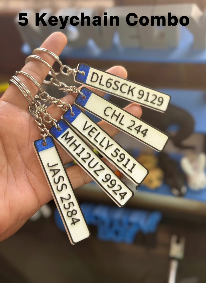 Hand holding multiple license plate keychains with various numbers and letters.