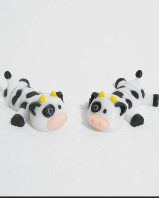 Two cow-shaped cake toppers on a white background