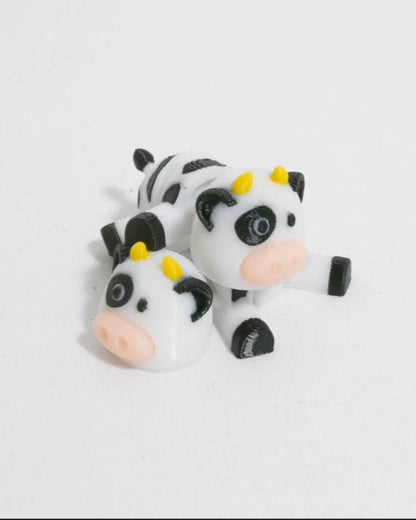 Two cow-shaped figurines on a white background