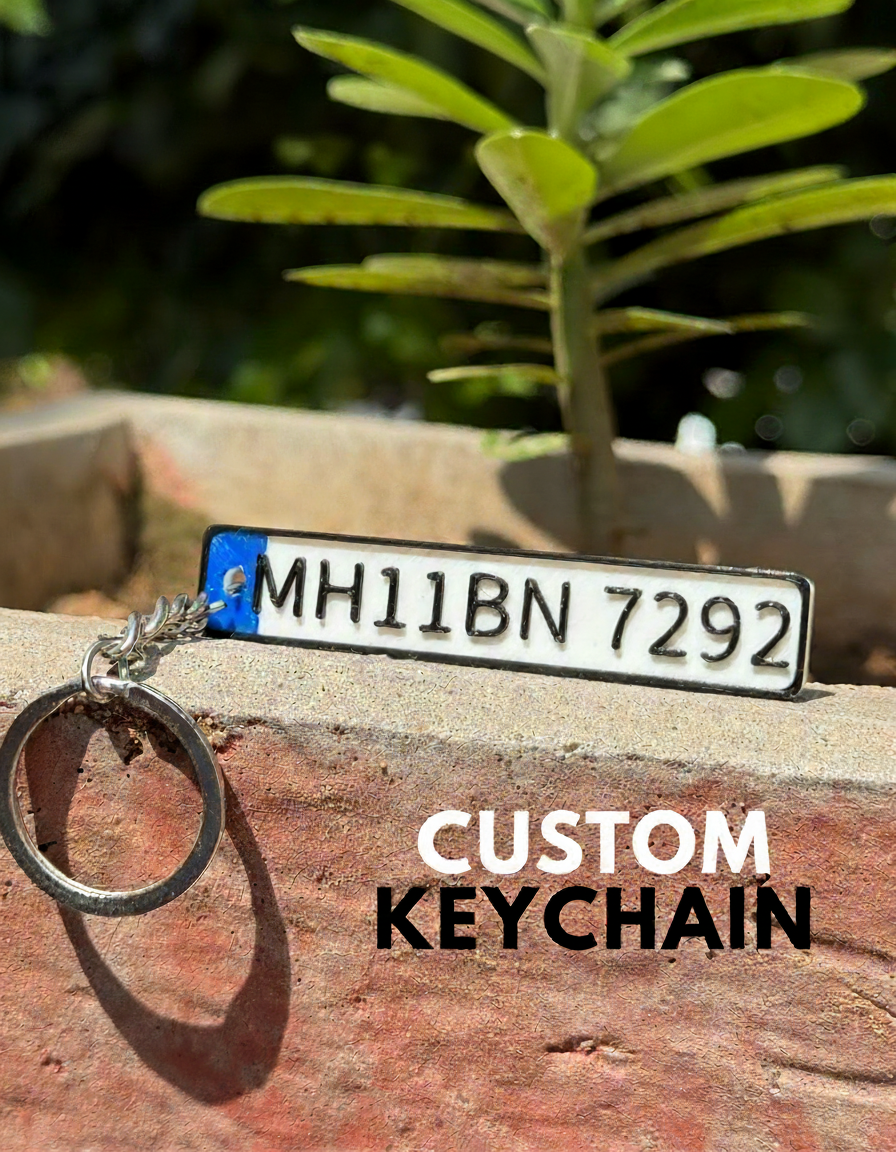Custom keychain with license plate design on a wooden surface with greenery in the background