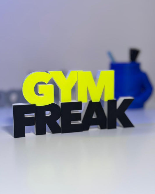 3D printed text 'GYM FREAK' with a blurred background