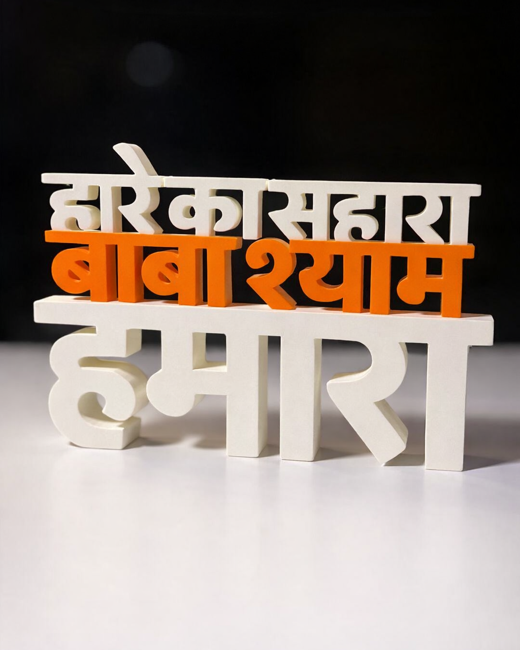 Decorative nameplate with Hindi text on a white surface