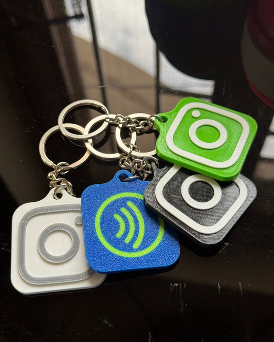 Set of keychains with social media icons on a reflective surface