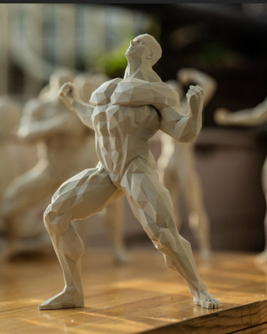 Muscular figure sculpture on a wooden surface with blurred background