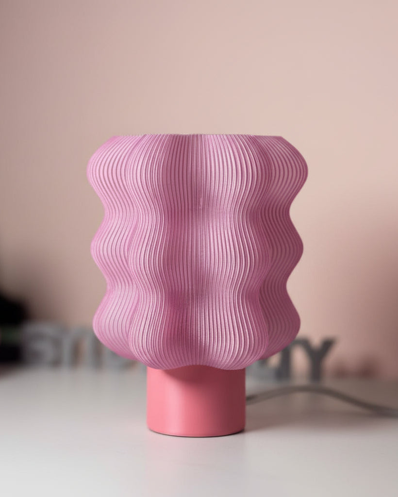 Pink textured vase on a white surface with a blurred background