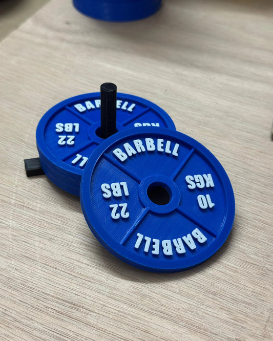 Blue weight plates with 'Barbell' branding on a wooden surface