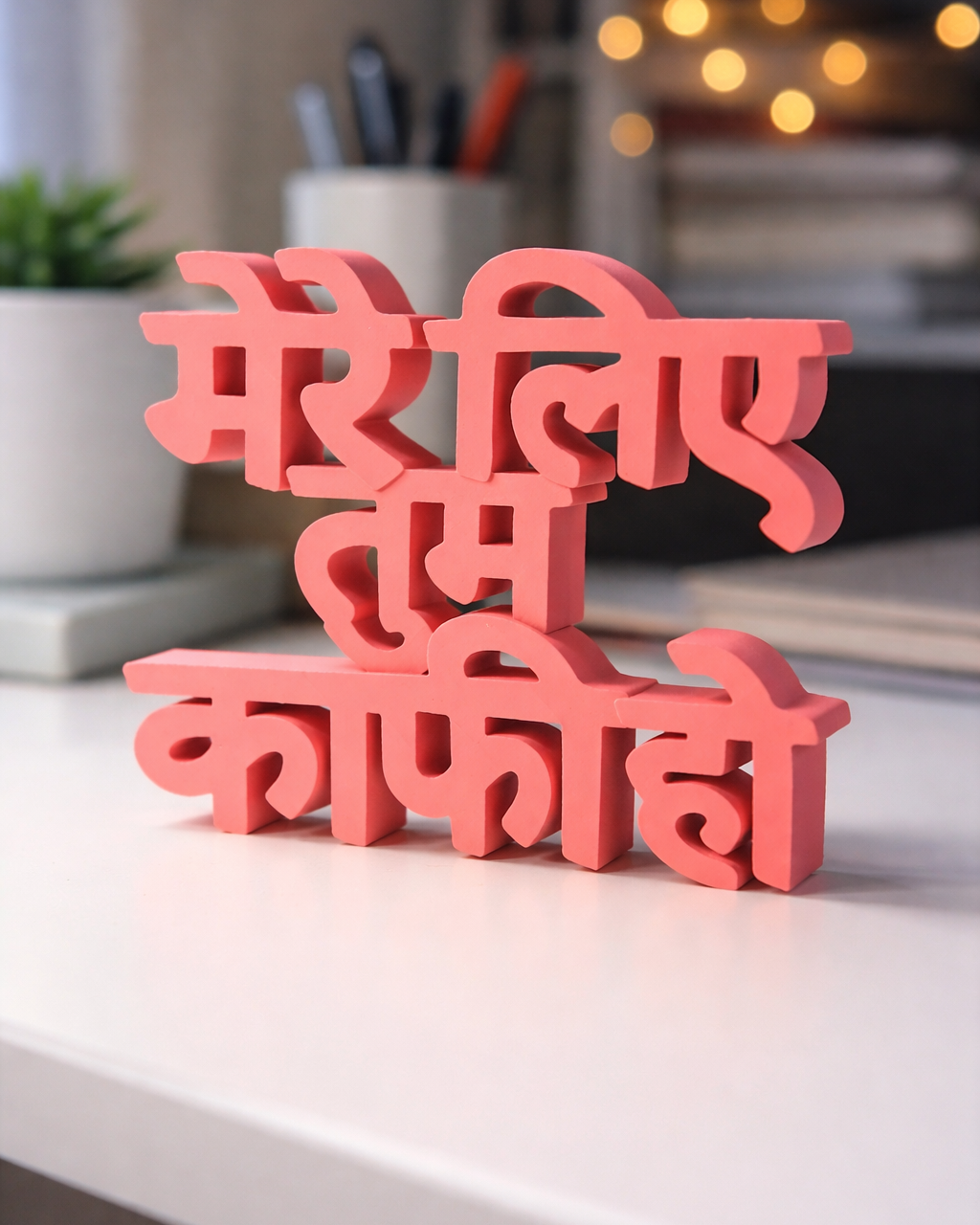 Pink decorative sign with text on a white surface