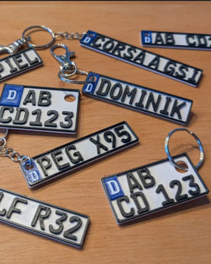 Collection of license plate keychains on a wooden surface