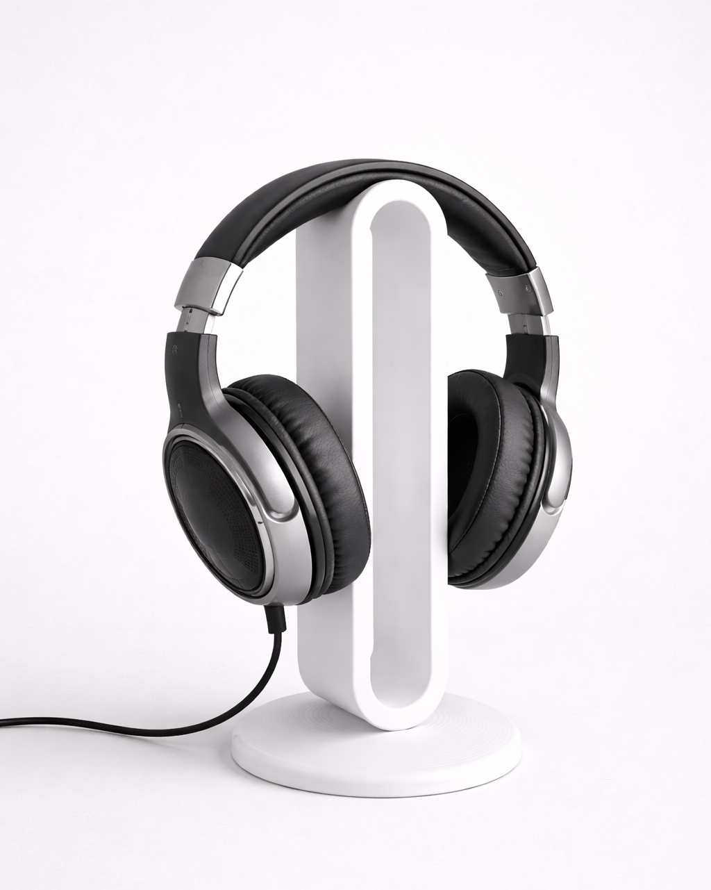 Black headphones on a white stand against a white background